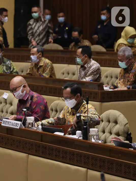 Menteri Dalam Negeri (Mendagri) Tito Karnavian (kanan) menghadiri rapat dengar pendapat (RDP) dengan Komisi II di gedung DPR RI, Jakarta, Selasa (19/1/2021). Rapat tersebut membahas evaluasi pelaksanaan pemilihan kepala daerah (Pilkada) 2020 pada 9 Desember  lalu. (Liputan6.com/Angga Yuniar)