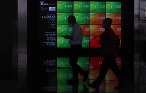 Pekerja melintas di depan layar Indeks Harga Saham Gabungan (IHSG) di BEI, Jakarta, Senin (3/1/2022). Pada pembukan perdagagangan bursa saham 2022 Indeks Harga Saham Gabungan (IHSG) langsung menguat 7,0 poin atau 0,11% di level Rp6.588,57. (Liputan6.com/Angga Yuniar)