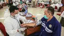 Petugas medis mengecek kesehatan pekerja yang akan mengikuti vaksinasi COVID-19 di Gedung Kemenaker, Jakarta, Selasa (4/5/2021). Untuk memperingati Hari Buruh Internasional atau May Day, pemerintah melakukan vaksinasi bagi 1.000 pekerja. (Liputan6.com/Faizal Fanani)
