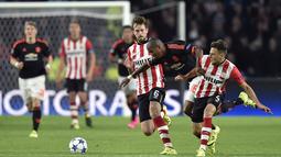 Pemain PSV,  Danny Propper (tengah) berebut bola dengan pemain MU,  Ashley Young, dalam pertandingan Grup B Liga Champions yang berlangsung di Stadion Philips, Eindhoven, Belanda. Selasa (12/9/2015). (AFP Photo/John Thys)
