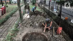 Pekerja menyelesaikan pembangunan sumur resapan di RPTRA Meruya Utara, Jakarta, Selasa (25/1/2022). Pembangunan 100 titik sumur resapan ini bertujuan untuk mengantisipasi banjir yang kerap terjadi di wilayah tersebut. (merdeka.com/Iqbal S. Nugroho)