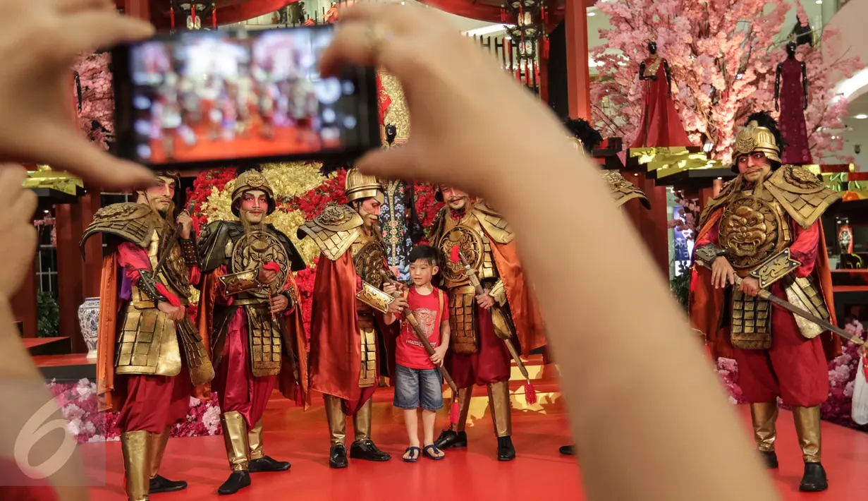 Seorang pengunjung tengah mengabadikan sejumlah seniman yang mengenakan busana Dinasti China Swing of Empire Warrior perayaan Tahun Baru Imlek 2568 di Senayan City, Jakarta Jakarta Sabtu (28/01). (Liputan6.com/Fery Pradolo)