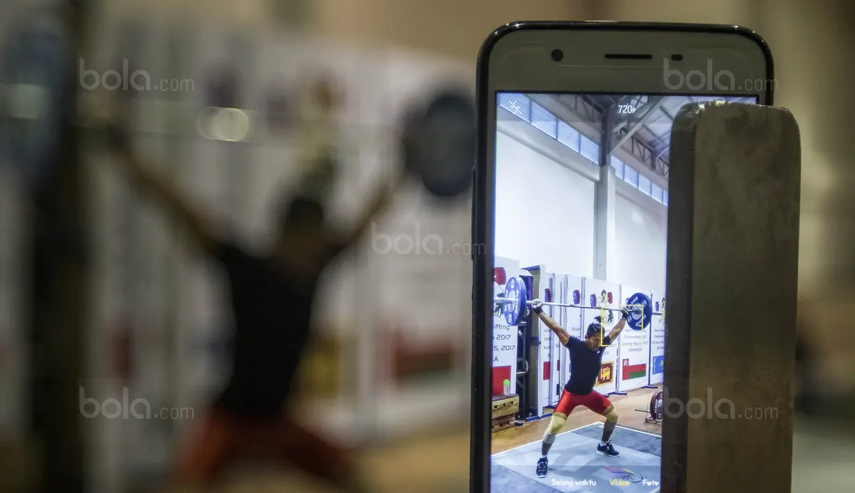 Lifter Indonesia, Deni, melakukan angkatan saat latihan di Gymnasium Sabilulungan, Jumat (21/7/2017). Tim angkat besi Indonesia melakukan persiapan jelang SEA Games 2017 Malaysia. (Bola.com/Vitalis Yogi Trisna)