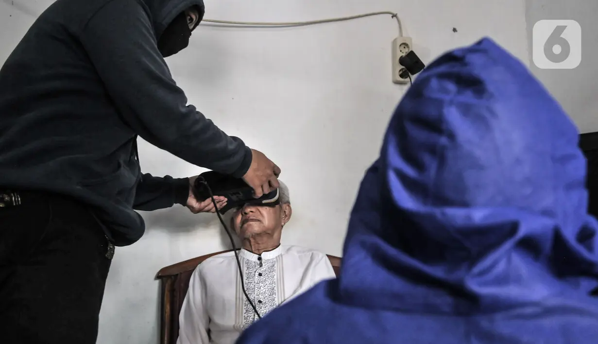 Petugas Disdukcapil Kota Jakarta Utara merekam E-KTP penyandang disabilitas di Pademangan Barat, Jakarta, Kamis (16/7/2020). Program jemput bola ini untuk memudahkan pelayanan administrasi kependudukan bagi penyandang disabilitas, jompo dan orang sakit di masa pandemi. (merdeka.com/Iqbal S. Nugroho)