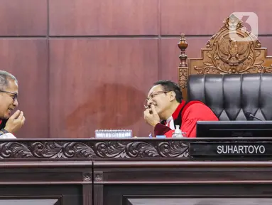 Ketua Mahkamah Konstitusi (MK) Suhartoyo (kanan) berbicara dengan Hakim Konstitusi Saldi Isra (kiri) di sela sidang perkara Nomor 145/PUU-XXI/2023 di Gedung MK, Jakarta, Selasa (16/1/2024). (Liputan6.com/Angga Yuniar)