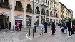 Orang-orang menjaga jarak saat antre untuk berbelanja di sebuah supermarket di Milan pada 10 Maret 2020. Wabah Virus Corona memaksa Italia memberlakukan Lock Down, atau karantina yang mencakup tidak adanya pertemuan di ruang publik, hingga anjuran agar menjaga jarak. (MIGUEL MEDINA/AFP)