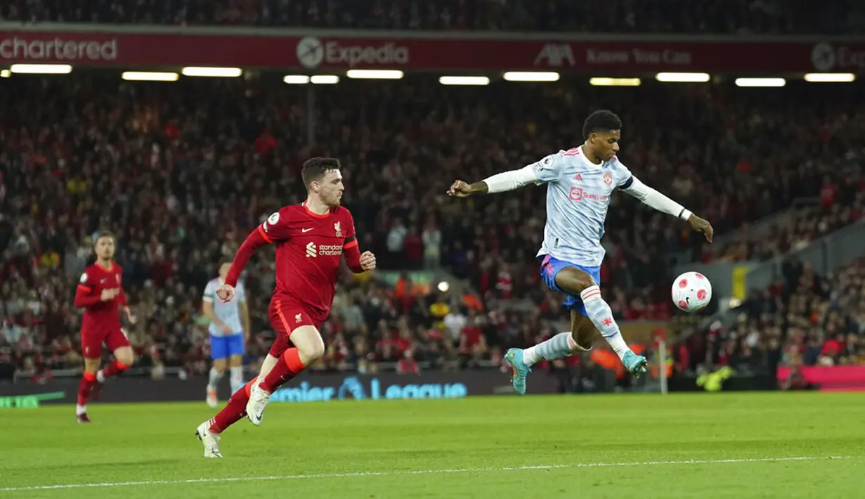 Pemain Manchester United Marcus Rashford (kanan) menggiring bola melewati pemain Liverpool Andrew Robertson pada pertandingan sepak bola Liga Inggris di Stadion Anfield, Liverpool, Inggris, 19 April 2022. Liverpool menang 4-0. (AP Photo/Jon Super)