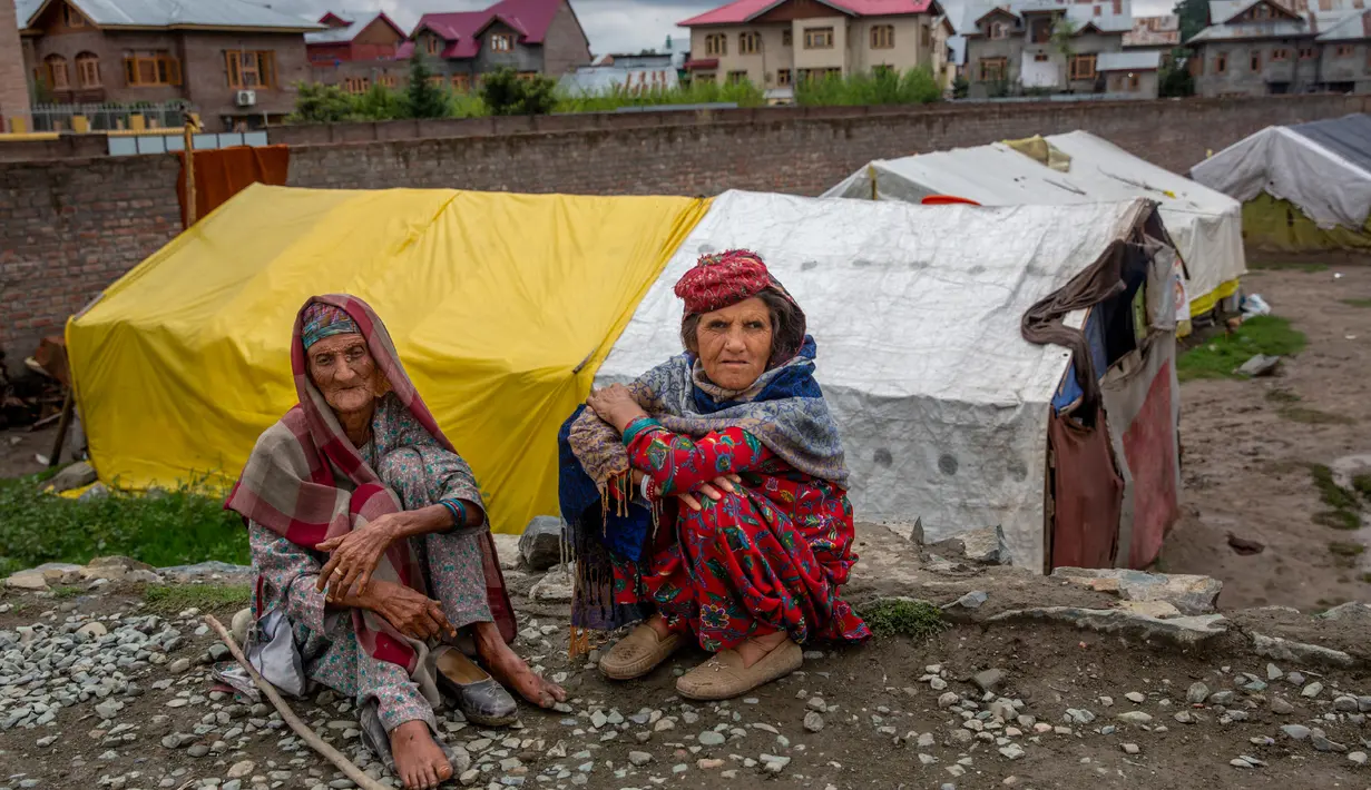 Gowri Khan dan Khatija, perempuan pengembara Kashmir Bakarwal duduk di luar kamp sementara di pinggiran Srinagar, India, 31 Agustus 2020. Suku Bakarwals adalah kaum penggembala nomaden di Jammu Kashmir, yang berpindah-pindah mencari padang rumput yang baik untuk ternak mereka. (AP Photo/Dar Yasin)