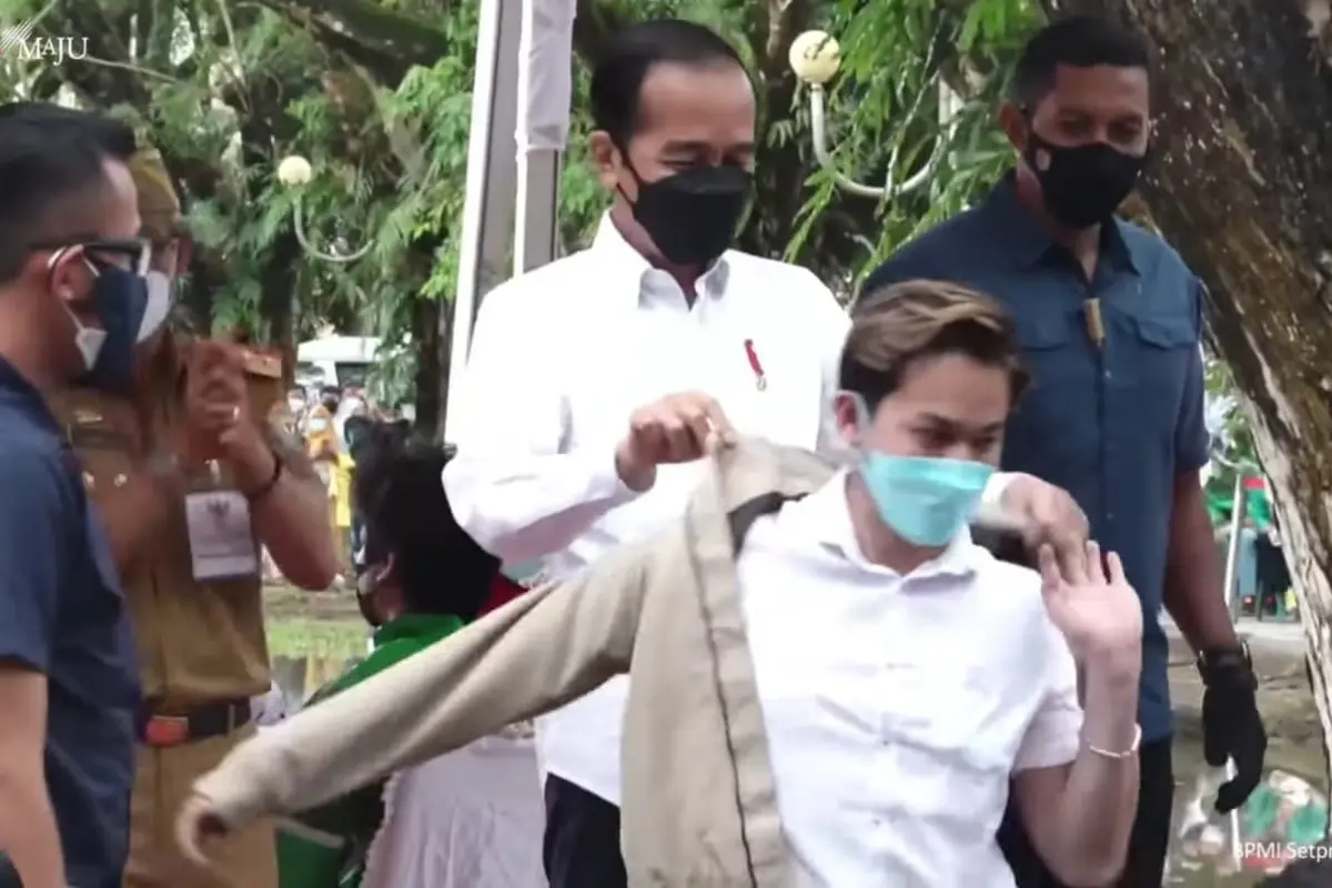 Jokowi memberikan jaket kepada salah seorang warga peserta vaksinasi massal saat mengunjungi Kota Kendari pada pembukaan Munas Kadin VIII.(Liputan6.com/isitimewa)