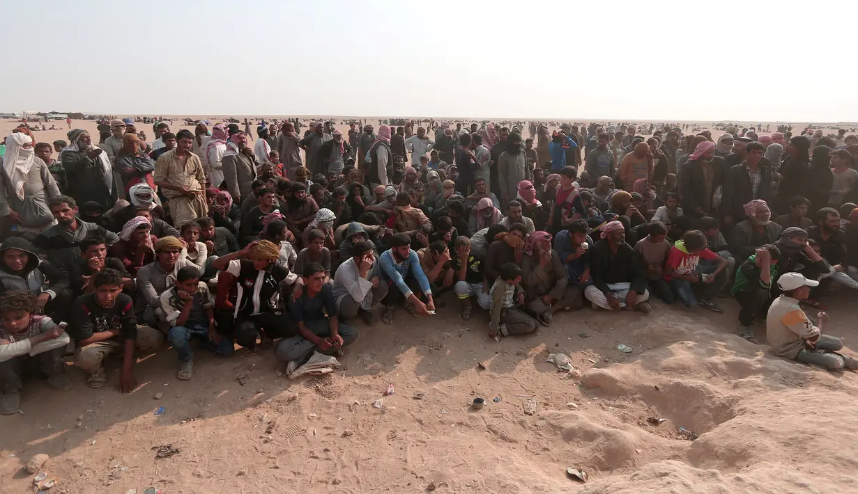 Pengungsi Irak beristirahat menunggu bantuan di dekat perbatasan Irak, di Hasaka Governorate (23/10). Para pengungsi Irak dan Suriah terlantar di tengah iklim gurun yang panas dan bahkan mendirikan tenda kecil untuk beristirahat. (REUTERS/Rodi Said)