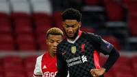 Bek Liverpool, Joe Gomez mengontrol bola di depan pemain Ajax Amsterdam, David Neres pada pertandingan pertama Grup D Liga Champions 2020 di Johan Cruijff Arena, Kamis (22/10/2020) dini hari WIB. Liverpool susah payah menang tipis 1-0 di kandang Ajax. (AP Photo/Peter Dejong)