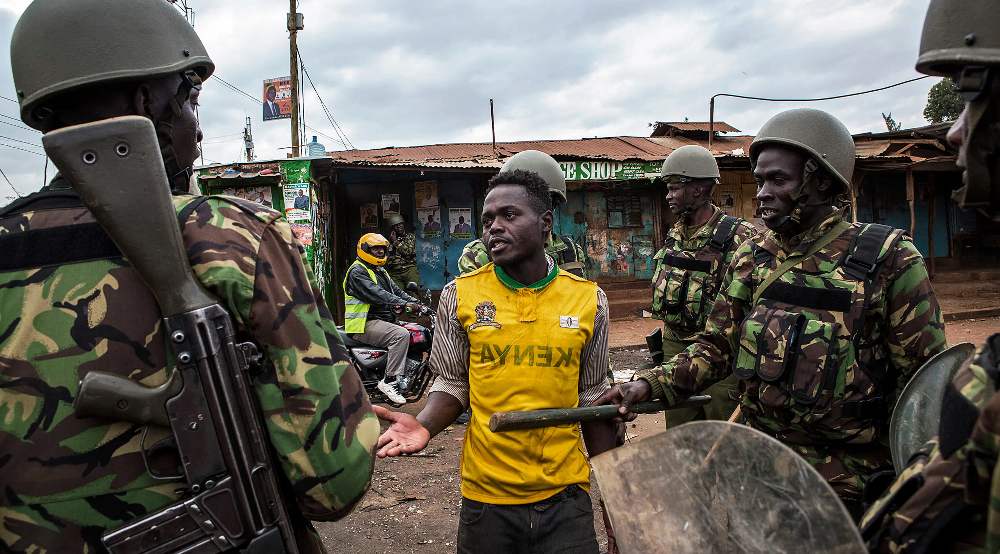 Polisi Kenya menginterogasi demonstran di daerah Kawangware di Nairobi, Kenya (10/8). Presiden Kenya Uhuru Kenyatta menang dalam pemilihan presiden, Jumat (11/8/2017) waktu setempat. (AFP Photo/Patrick Meinhardt)