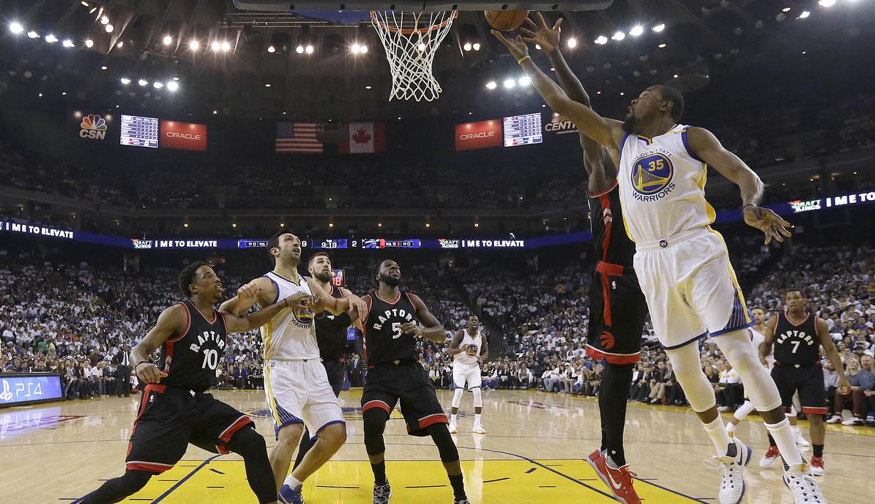 Pemain Golden State Warriors, Kevin Durant #35 melakukan tembakan saat dihadang pemain Toronto Raptors pada lanjutan NBA basketball game di Oracle Arena, (28/12/2016). Warriors menang 121-111. (AP/Jeff Chiu)