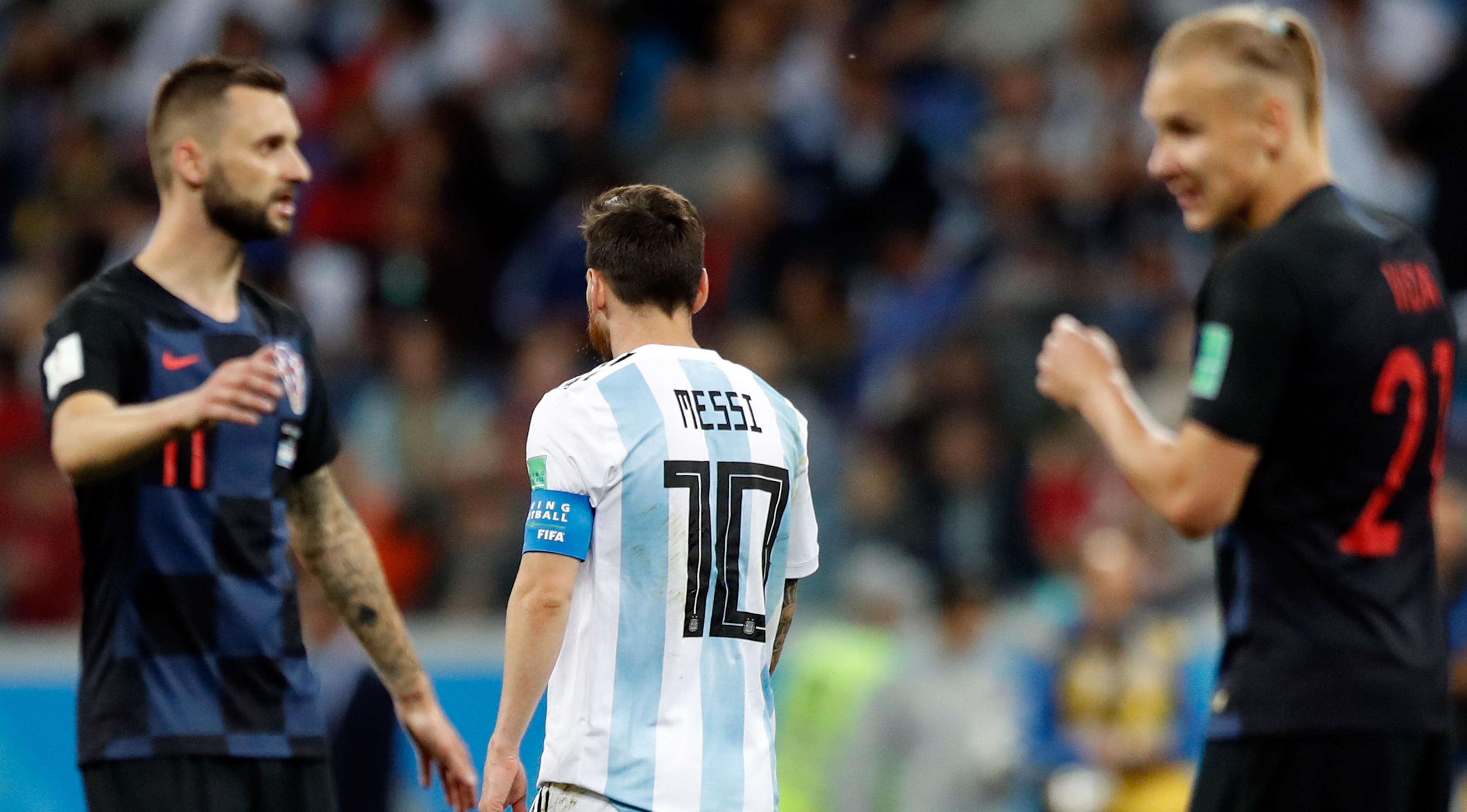 Kapten timnas Argentina, Lionel Messi meninggalkan lapangan ketika pemain Kroasia merayakan kemenangan pada pertandingan Grup D Piala Dunia 2018 di Nizhy Novgorod Stadium, Jumat (22/6). Argentina harus mengakui keunggulan Kroasia 0-3. (AP/Pavel Golovkin)
