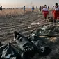 Tim penyelamat mengumpulkan jasad korban jatuhnya pesawat Boeing 737-800 di Shahedshahr, Iran, Rabu (8/1/2020). Pesawat sempat terbakar di udara sebelum akhirnya jatuh di lahan pertanian. (AP Photo/Ebrahim Noroozi)