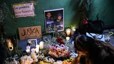 Seorang wanita meletakkan lilin di altar sebagai penghormatan bagi jurnalis yang tewas akibat serangan Israel di Jalur Gaza, saat menghadiri doa bersama di Mexico City pada 12 Agustus 2025. (Yuri CORTEZ/AFP)