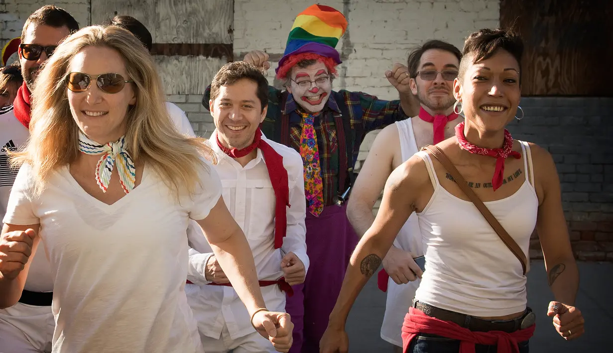 Peserta berdandan seperti badut mengejar pejalan kaki selama acara parodi tahunan "Running of the Clowns" di Pasadena, California pada 20 Oktober 2019. Lari dikejar kawanan badut ini merupakan parodi yang mengolok-olok lomba dikejar banteng di Spanyol. (Mark RALSTON / AFP)