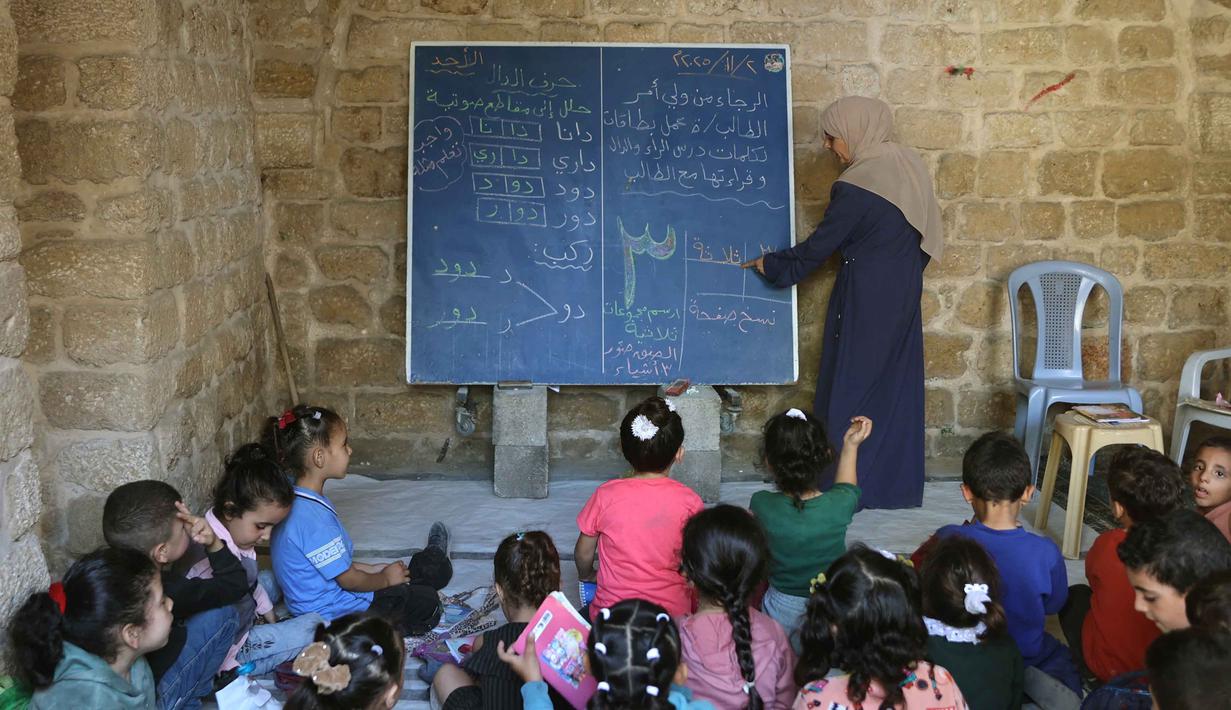 Anak-anak Palestina menghadiri kelas di sekolah bersejarah "Al-Kamaliya al-Othmanya" di Kota Tua Gaza yang menjadi bagian dari inisiatif sukarelawan yang diorganisir oleh para guru pengungsi, di Kota Gaza pada 2 November 2025. Di sisi lain, menurut data PBB, lebih dari 97 persen sekolah di Gaza mengalami kerusakan selama konflik. (Omar AL-QATTAA/AFP)