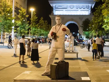 Seorang peserta berpakaian patung tampil dalam Statue Fest 2020 dengan tema "Skopje Disaat Corona", di alun-alun utama Skopje, Ibu Kota Makedonia Utara, 5 September 2020. Festival ini diselenggarakan oleh "Teatrosk" produksi teater jalanan yang menampilkan berbagai figur. (Robert ATANASOVSKI/AFP)