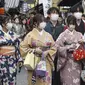 Sejumlah perempuan berpakaian tradisional kimono berjalan di sepanjang tujuan wisata di Kyoto, Jepang barat, Senin (13/3/2023). Meski aturan penggunaan masker telah dilonggarkan,  banyak orang di tempat-tempat umum dan tempat berkumpul yang masih menggunakan masker. (Kyodo News via AP)