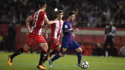 Bintang Barcelona, Lionel Messi, berusaha melewati bek Girona, Juanpe Ramirez, pada laga La Liga Spanyol di Stadion Montilivi, Girona, Sabtu (23/9/2017). Girona kalah 0-3 dari Barcelona. (AFP/Josep Lago)