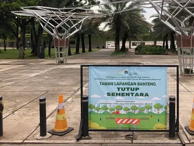Pengumuman penutupan sementara Taman Lapangan Banteng terlihat di Jakarta, Minggu (20/9/2020). Seluruh taman kota dan hutan kota ditutup kembali untuk sementara terkait pemberlakuan PSBB total di Jakarta guna menekan penyebaran virus covid-19. (Liputan6.com/Immanuel Antonius)