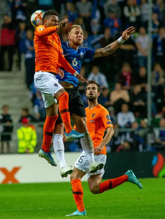 Penyerang Belanda, Donyell Malen (kiri) dan gelandang Estonia, Martin Miller berebut bola saat bertanding dalam kualifikasi Grup C Euro 2020, di Tallinn, Estonia, Senin (9/9/2019). Belanda mengalahkan Estonia dengan skor 4-0. (Raigo Pajula/AFP)