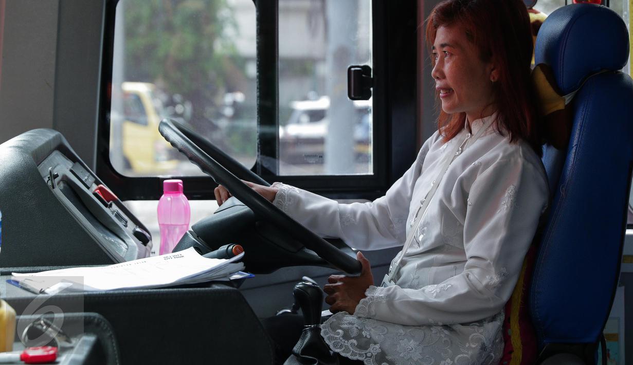 Seorang pramudi mengenakan kebaya saat mengendarai bus tingkat wisata TransJakarta di Jakarta, Jumat (21/4). Dalam rangka Hari Kartini, semua pramudi perempuan bus pariwisata dan Transjakarta mengenakan kebaya. (Liputan6.com/Faizal Fanani)