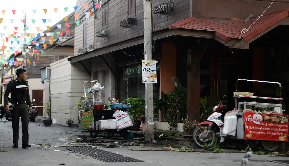 Seorang polisi berjalan di lokasi ledakan bom kembar di kawasan resor Hua Hin, Thailand, Jumat (12/8). Ledakan yang terjadi tepat tengah malam di wilayah cukup terkenal di kalangan turis itu mewaskan satu orang. (Munir Uz ZAMAN/APF/AFP)