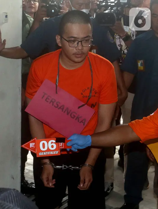 Tersangka Altaf yang berkacamata terlihat tertunduk lesu saat mengenakan baju tahanan berwarna oranye dengan tangan terborgol. (merdeka.com/Arie Basuki)
