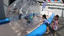 Anak-anak bermain bola raksasa yang menjadi salah satu arena bermain di Karnaval SEA Games. (Bola.com/Arief Bagus)