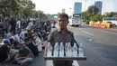 Seorang pedagang minum berjualan di jalan tol dalam kota yang berada di depan Gedung DPR RI, Jakarta, Senin (30/9/2019). Adanya aksi unjuk rasa di sekitar lokasi dimanfaatkan para pedagang asongan untuk mencari rezeki. (Liputan6.com/Immanuel Antonius)