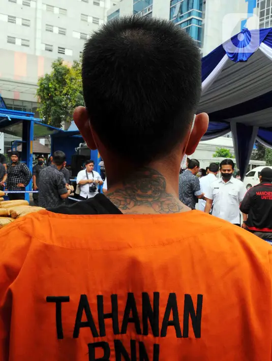 Tersangka dihadirkan saat pemusnahan barang bukti ganja di Lapangan Gedung BNN, Jakarta, Rabu (18/1/2023). BNN memusnahkan barang bukti 222,697 kilogram ganja dan menangkap empat tersangka berinisial AE alias Adul, RJ, MF, dan G yang merupakan narapidana Lapas Kelas I Tangerang dari pengiriman paket kargo di depan Mall Cijantung. (merdeka.com/Imam Buhori)