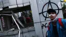 Seorang mahasiswa melintasi Pos Polisi yang dirusak massa di kawasan Gondangdia, Jakarta, Kamis (8/10/2020). Aksi anarkis massa dilakukan saat berunjuk rasa menentang disahkan Omnibus Law UU Cipta Kerja. (Liputan6.com/Helmi Fithriansyah)