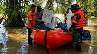 Distribusi logistik Pilkada 2024 menggunakan perahu karena banjir. (Liputan6.com/M Syukur)