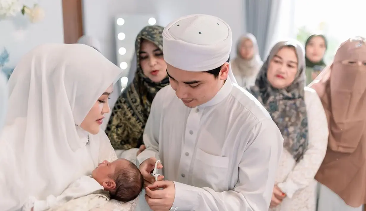 Alvin Faiz tampak berhati-hati saat mencukur rambut Mikail sebagai momen simbolis. Raut bahagia mereka begitu terpancar saat menggelar acara akikah. Tampak pula keluarga dan orang-orang terdekat hadir di acara tersebut. (Liputan6.com/IG/@malycaphoto)
