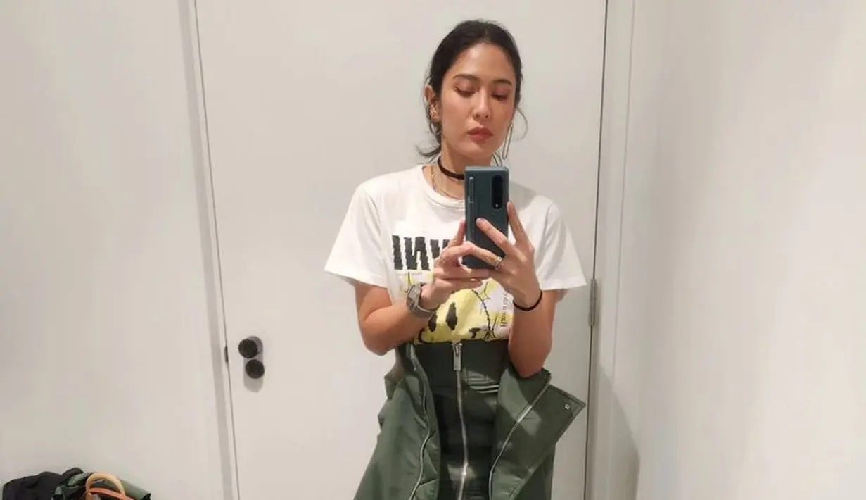Ibu dua anak ini juga tampil santai dengan kaos putih dipadukan rok hijau asimetris dan sepatu hitamnya.  [@therealdisastr]