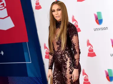 Penyanyi dan aktris Jennifer Lopez (J-Lo) berpose menghadiri Latin Grammy Awards ke-17 di T-Mobile Arena, Las Vegas, AS (17/11). Bergaun bernuansa ungu tua transparan J-Lo tampil cantik dan seksi dengan rambut terurai. (Ethan Miller/Getty Images/AFP)