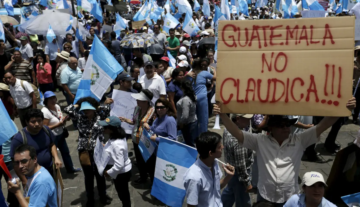 Seorang pria memegang poster saat unjuk rasa menuntut mundur Presiden Otto Perez di Guatemala City, Kamis (27/8/2015). Aksi ini dilakukan setelah Presiden Perez menolak mundur usai dituding terlibat skandal korupsi bea cukai. ( REUTERS/Jorge Dan Lopez)