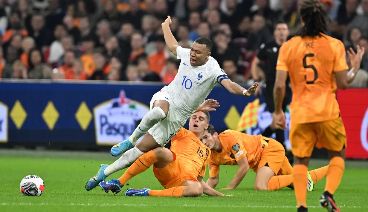 Pemain Prancis, Kylian Mbappe, terjatuh saat berusaha melewati pemain Belanda, Joey Veerman, pada Kualifikasi EURO 2024 Grup B di Stadion Johan Cruijff Arena, Sabtu (14/10/2023). Barisan pertahanan samapi harus melakukan pelanggaran untuk menghentikan Mbappe. (AFP/John Thys)