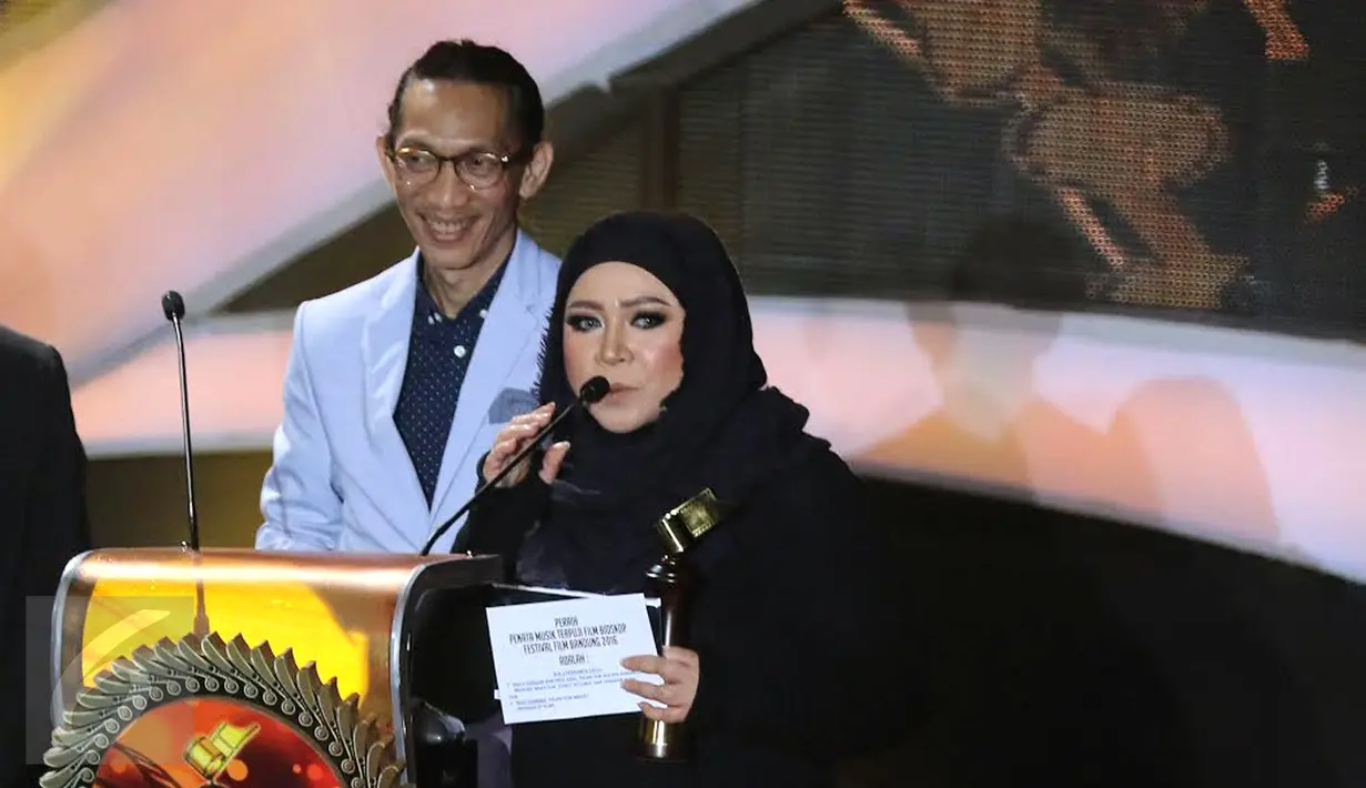Pasangan musisi Melly Goeslaw dan Anto Hoed meraih penghargaan di kategori Penata Musik Terpuji Festival Film Bandung (FFB) 2016 lewat film "AADC 2", di Monumen Perjuangan Rakyat Jawa Barat, Sabtu (24/9). (Liputan6.com/Herman Zakharia)
