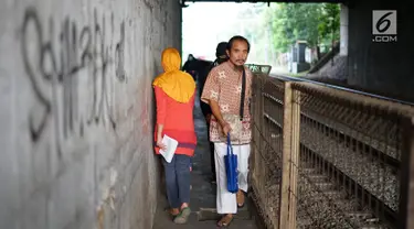 Pejalan kaki melintasi jalan setapak di sekitar Stasiun Cawang, Jakarta, Kamis (9/5). Meskipun sempit, jalan setapak tersebut masih menjadi pilihan sebagian pejalan kaki untuk menyeberangi Jalan Gatot Soebroto, dibanding harus melewati JPO yang jaraknya lebih jauh. (Liputan6.com/Immanuel Antonius)