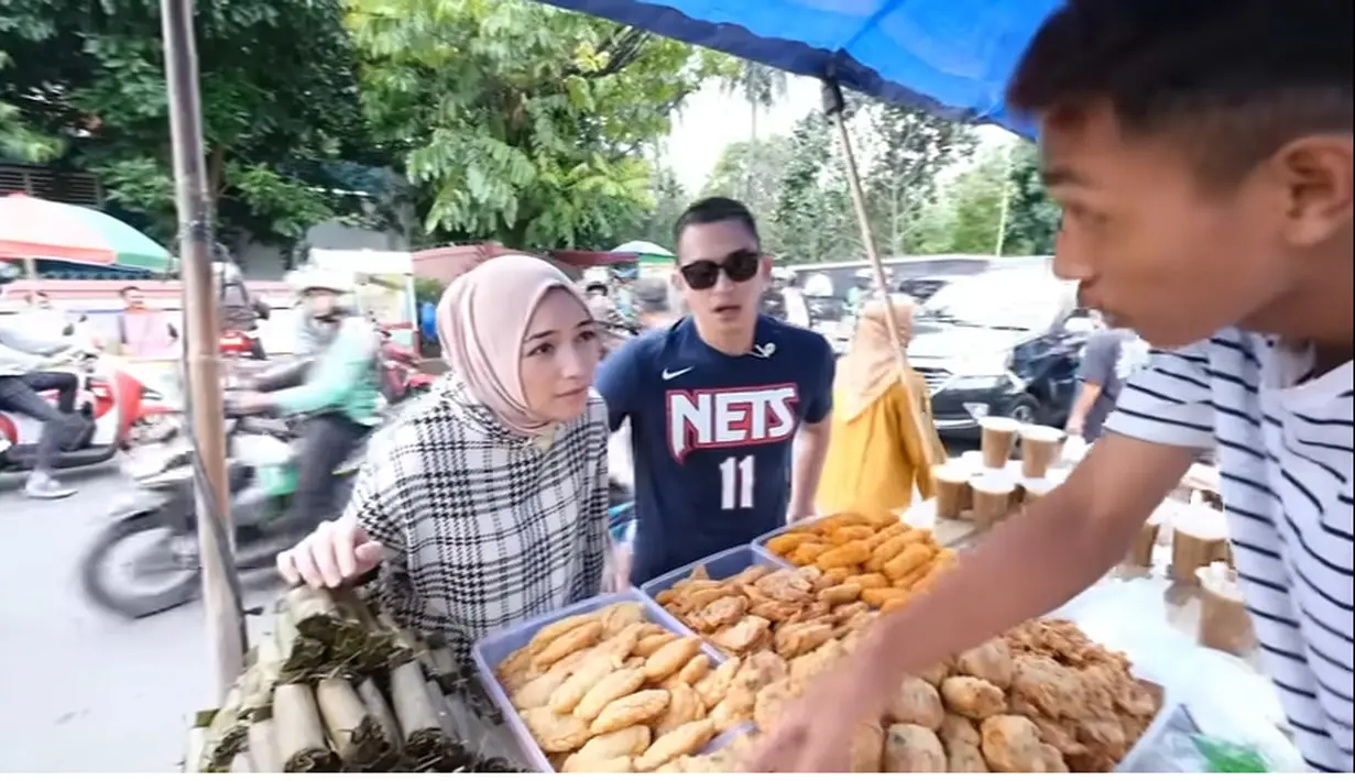 Selain gorengan,  yang tak luput dari pasangan ini adalah lontong. Keduanya tampak kompak membeli lontong, gorengan, hingga asinan. [Youtube/Ciky Citra Rezky]