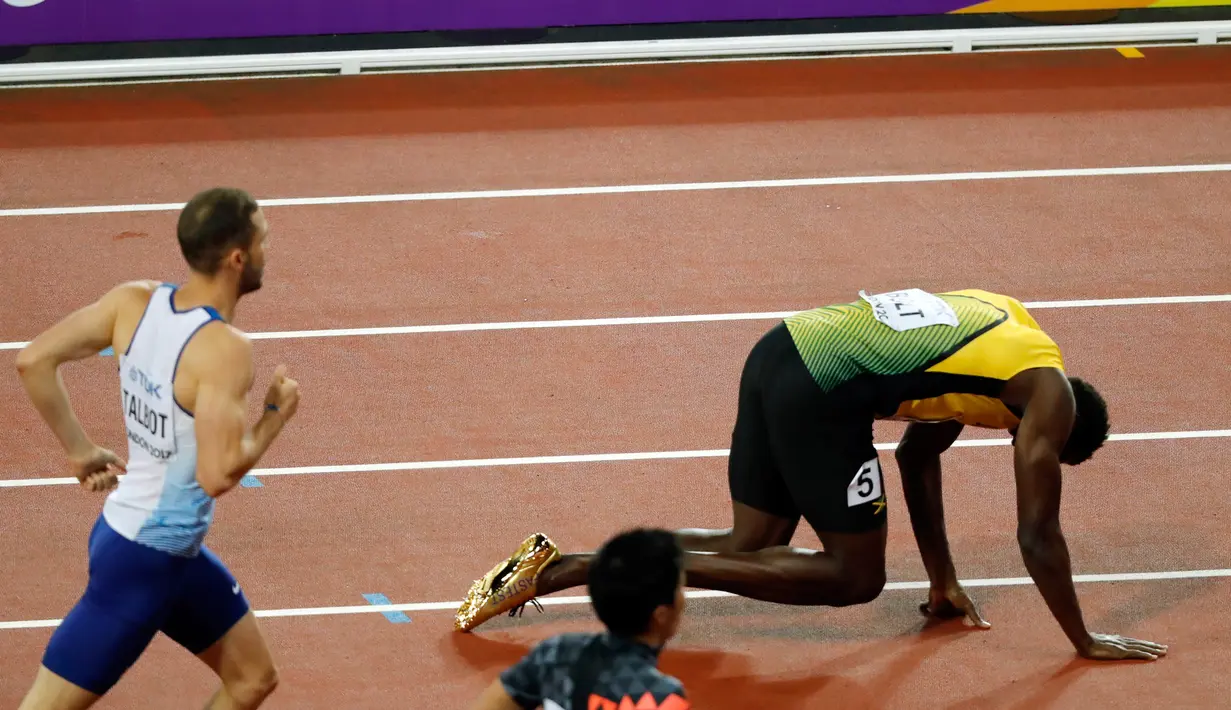 Pelari asal Jamaika, Usain Bolt terkapar di tengah lintasan setelah terjatuh di final 4x100 meter pada Kejuaraan Dunia Atletik di London, Sabtu (12/8). Bolt yang berencana ingin pensiun itu terjatuh karena kaki kirinya kram. (AP/Frank Augstein)