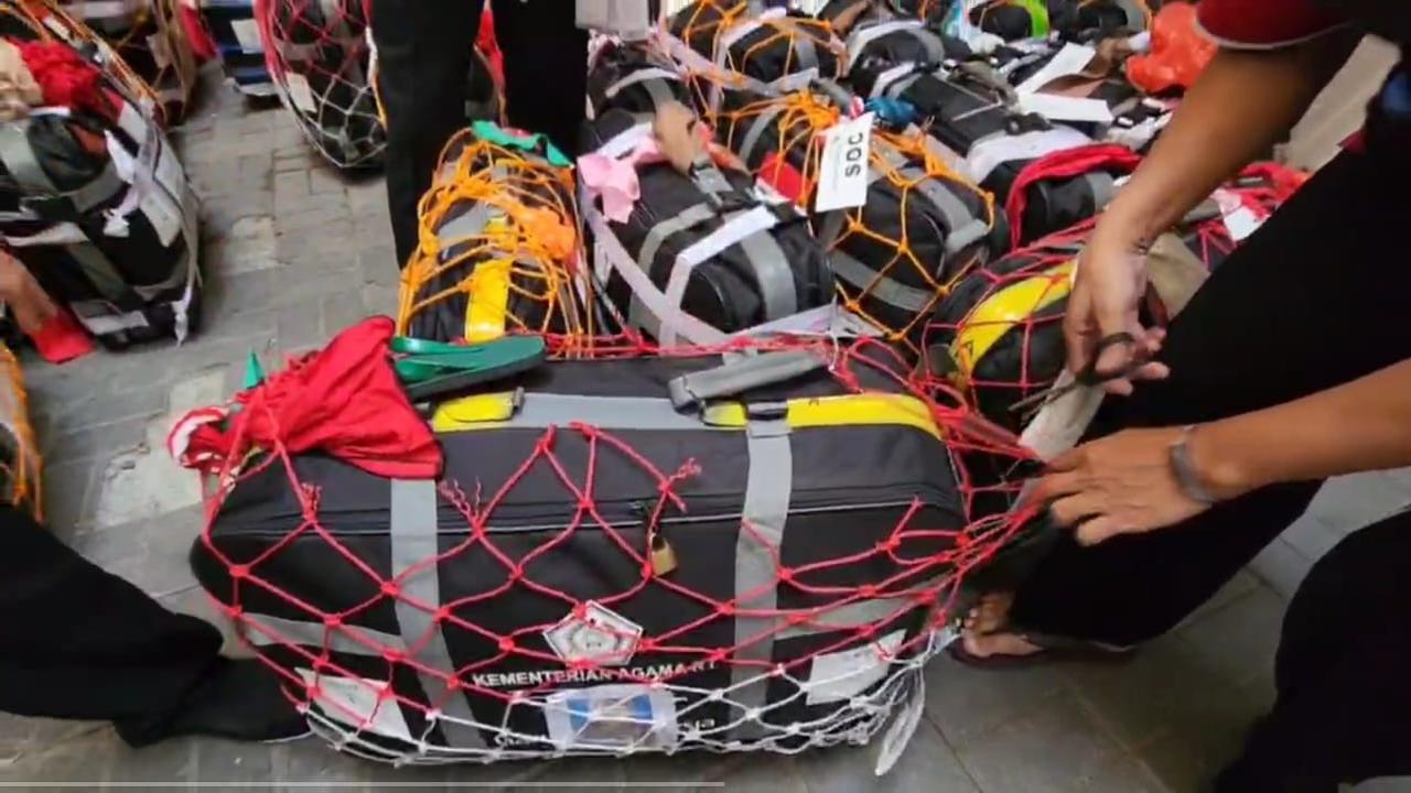 Petugas menggunting jaring koper jemaah haji Indonesia. (Liputan6.com/Mevi Linawati)