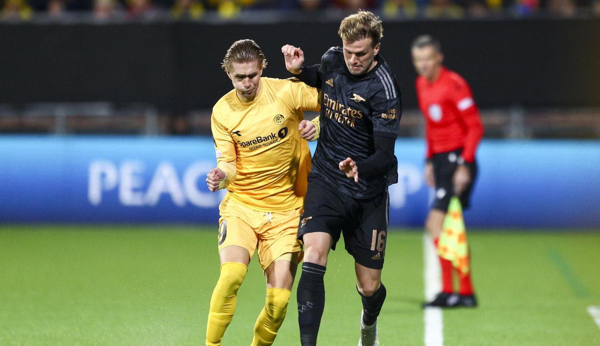 <p>Penyerang Bodo/Glimt, Ola Solbakken (kiri) dan bek Arsenal Rob Holding berebut bola pada pekan ke-4 Grup A Liga Europa 2022/2023 di Aspymra Stadion, Norwegia, Kamis malam (13/10/2022). Gol semata wayang Arsenal dicetak Bukayo Saka. (Photo by Mats Torbergsen / NTB / AFP)</p>