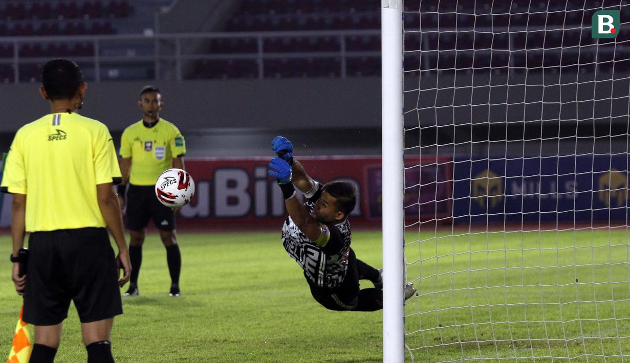 Kiper Persija Jakarta, Andritany Ardhiyasa berhasil menggagalkan tendangan pemain PSM Makassar dalam babak adu penalti leg kedua semifinal Piala Menpora 2021 di Stadion Manahan, Solo, Minggu (18/4/2021). Persija menang 4-3 atas PSM. (Bola.com/Ikhwan Yanuar)