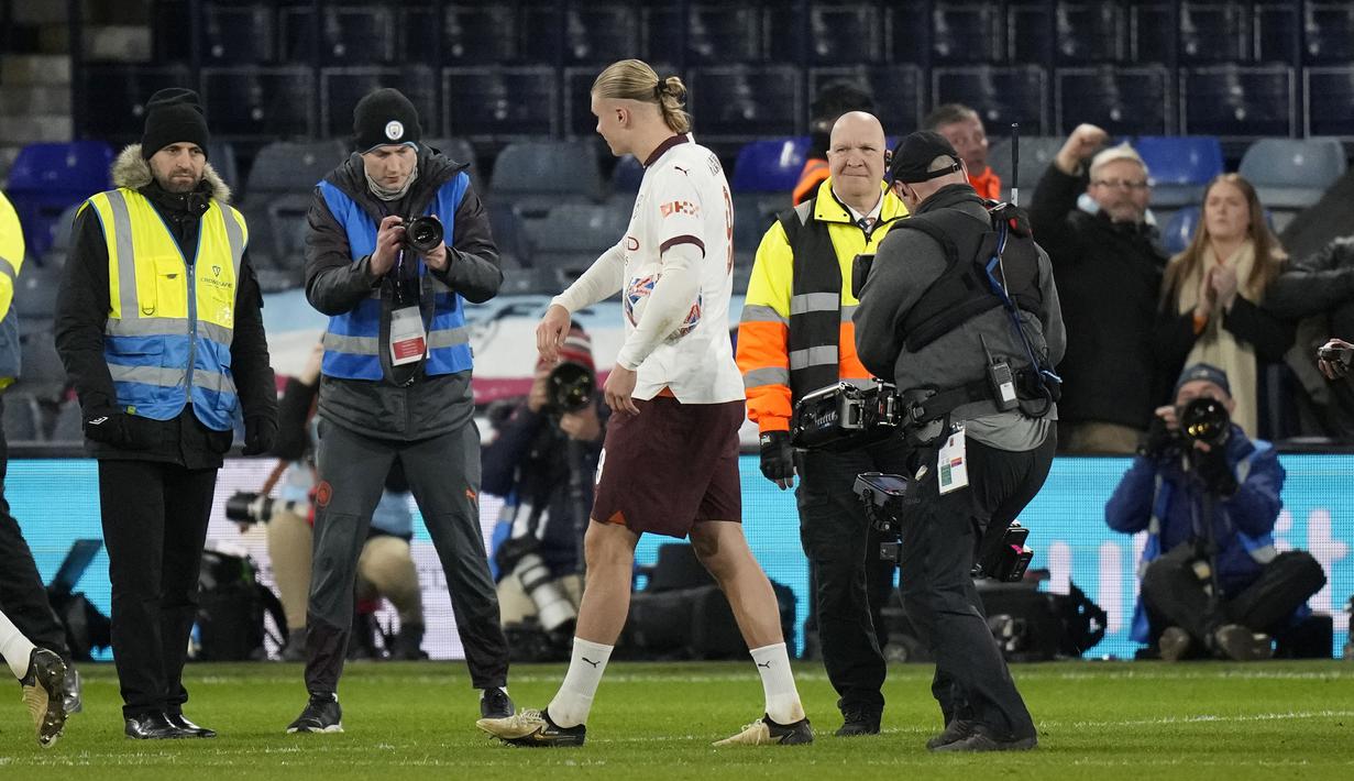 Striker Manchester City, Erling Haaland yang mencetak lima gol ke gawang Luton Town berjalan meninggalkan lapangan dengan membawa bola setelah berakhirnya laga putaran kelima Piala FA 2023/2024 dengan kemenangan 6-2 di Kenilworth Road Stadium, Luton, Selasa (27/2/2024). (AP Photo/Alastair Grant)