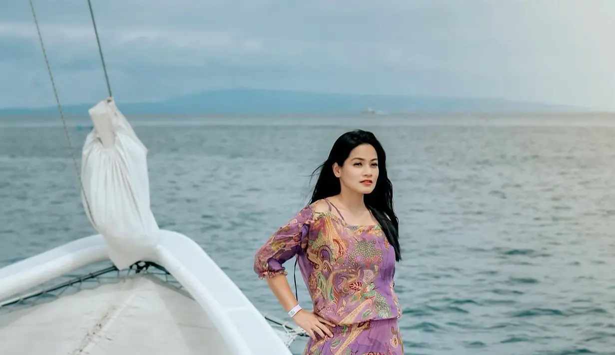 Tak sedikit yang memuji pakaiannya yang tetap terlihat santun tengah bermain di pantai. [Foto: IG/titi_kamall].