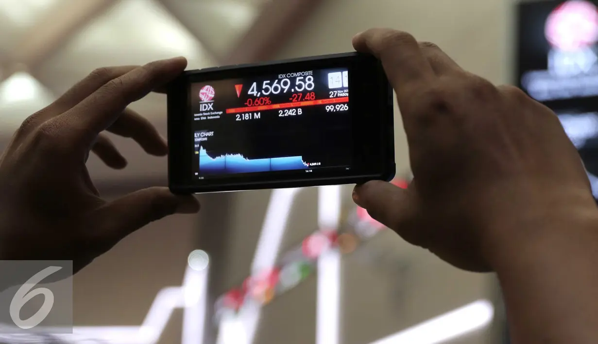 Pengunjung memfoto pergerakan Indeks Harga Saham Gabungan di Bursa Efek Indonesia, Jakarta,  Jumat (27/11). Bursa saham Indonesia kembali melemah pada penutupan perdagangan hari ini. (Liputan6.com/Angga Yuniar)